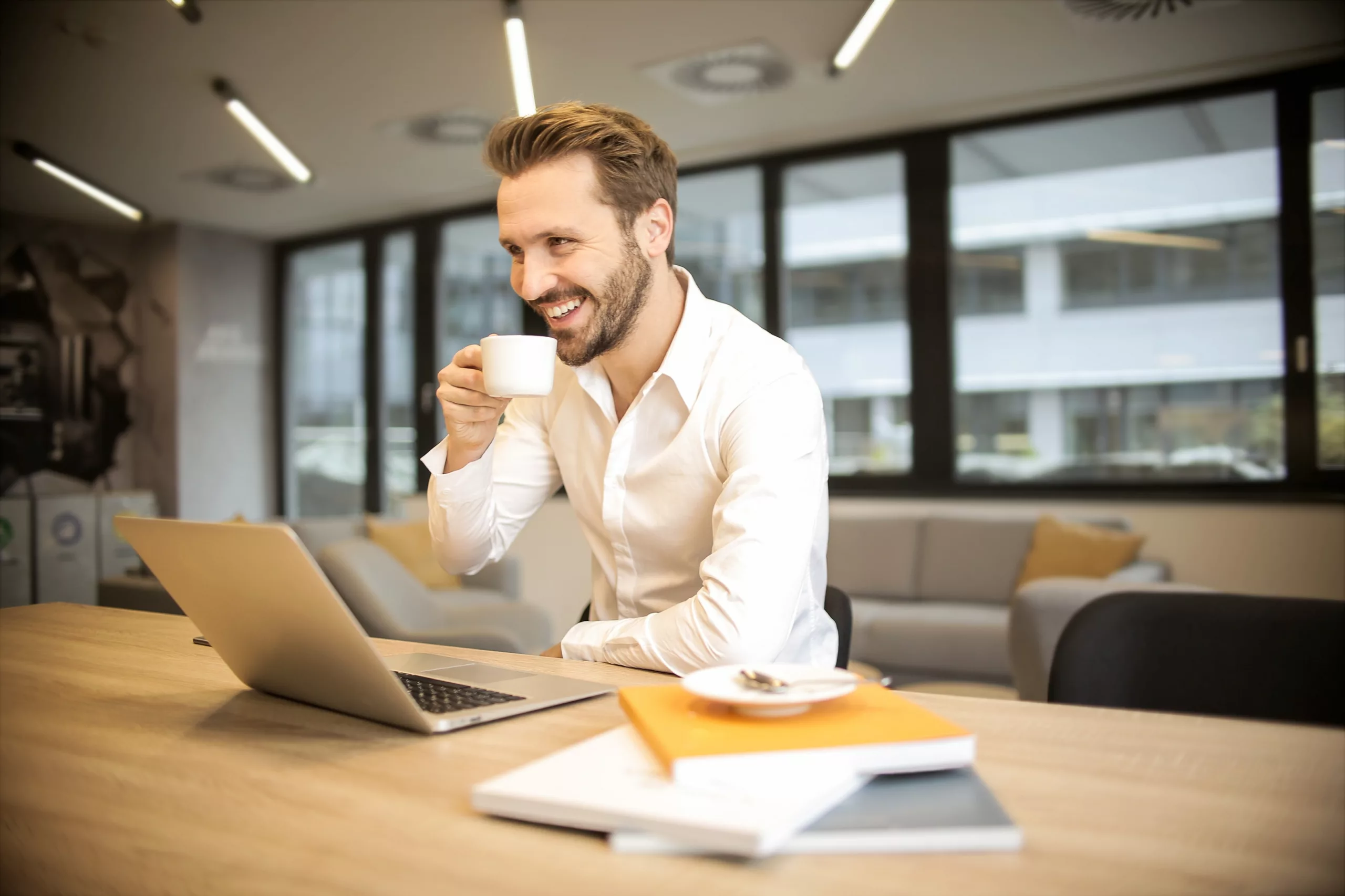 The Hierarchy of Testimonials. Young businessman, sipping coffee, looking happy about his testimonials.