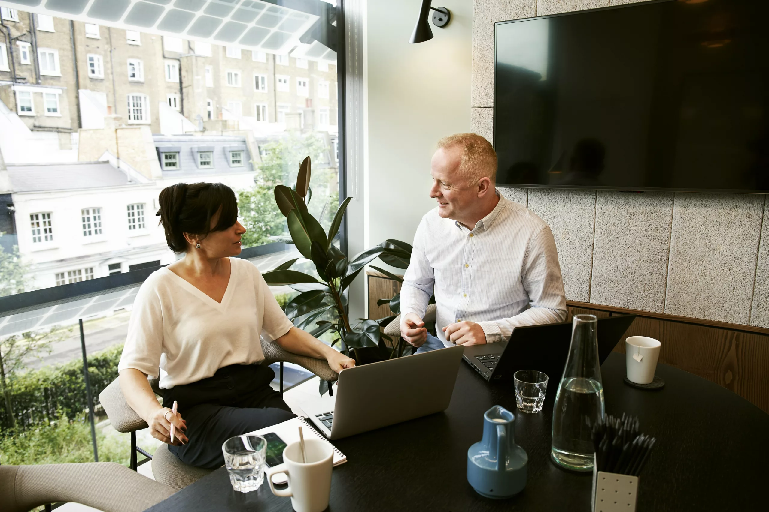 Go Behind the Scenes - Man and Woman talking in office, behind the scenes in their business